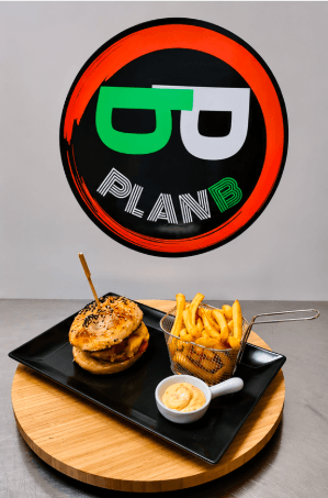 Smash burger et panier de frites servis devant le logo Plan B
