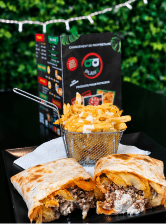 Tacos coupé en deux et panier de frites devant la carte du restaurant